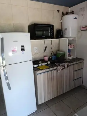 a kitchen with a white refrigerator and a microwave at Aves Del Monte in Santa Rosa de Calamuchita