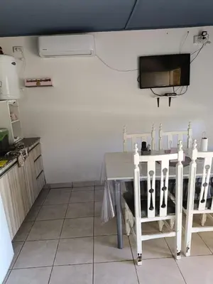 a dining room with a table and a tv at Aves Del Monte in Santa Rosa de Calamuchita