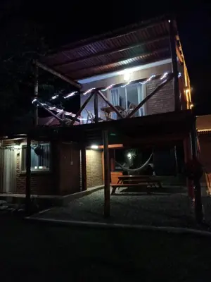 a bench in front of a building at night at Aves Del Monte in Santa Rosa de Calamuchita