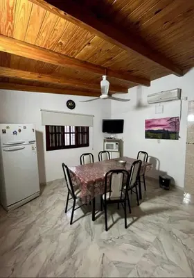 a dining room with a table and chairs and a refrigerator at Departamento de 2 a 5 personas in Villa Carlos Paz