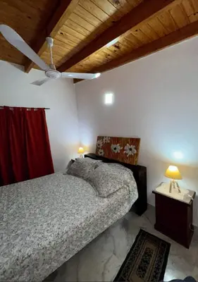 a bedroom with a bed and a ceiling fan at Departamento de 2 a 5 personas in Villa Carlos Paz