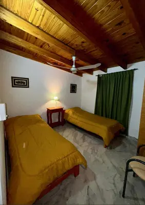 a bedroom with two beds and a table with a lamp at Departamento de 2 a 5 personas in Villa Carlos Paz