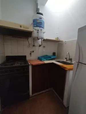 a kitchen with a stove and a sink and a refrigerator at Casa con Pileta, solo para familias in Villa Carlos Paz