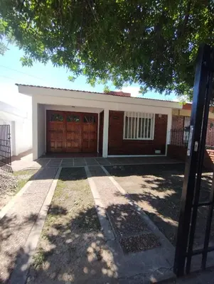 a house with a garage with a driveway at Casa con Pileta, solo para familias in Villa Carlos Paz