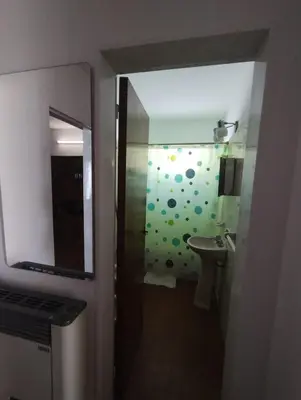 a bathroom with a shower with a sink and a mirror at Casa con Pileta, solo para familias in Villa Carlos Paz