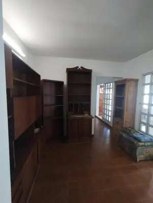 a living room with wooden cabinets and a large room with at Casa con Pileta, solo para familias in Villa Carlos Paz