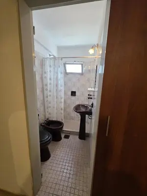 a bathroom with a sink and a toilet and a window at 165saavedra in Villa Carlos Paz