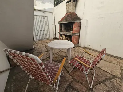 a patio with a table and two chairs and a table with a fireplace at 165saavedra in Villa Carlos Paz