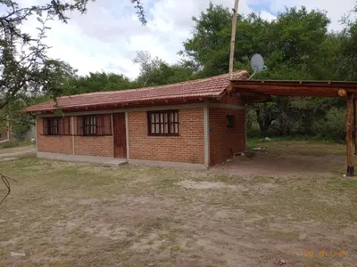 a small brick house with a red roof at Cabaña las chinitas in San Lorenzo
