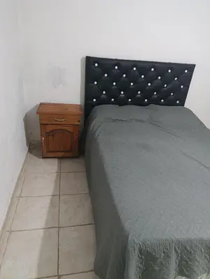 a bedroom with a bed and a wooden night stand at Soles in Cordoba