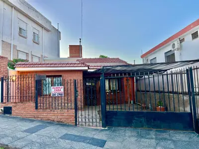 a building with a gate with a sign on it at La roca in Villa Carlos Paz