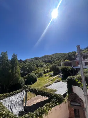 a view of a house with the sun in the sky at Carlos Paz, casa ideal para tus vacaciones soñadas in Villa Carlos Paz