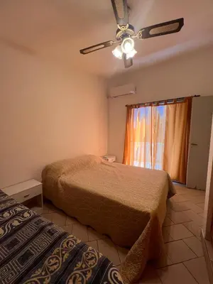 a bedroom with two beds and a ceiling fan at Carlos Paz, casa ideal para tus vacaciones soñadas in Villa Carlos Paz