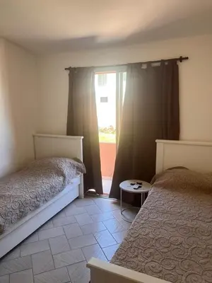 a bedroom with two beds and a door to a patio at Carlos Paz, casa ideal para tus vacaciones soñadas in Villa Carlos Paz