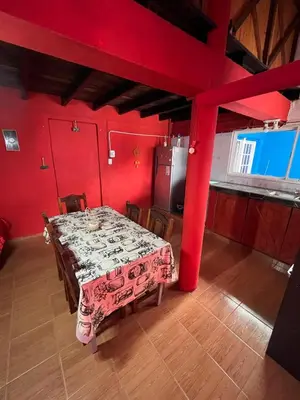 a dining room with a table and red walls at La Morada in Mina Clavero