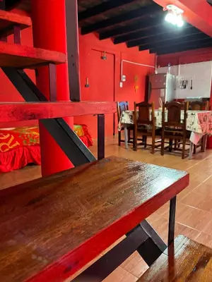 a wooden bench in a room with red walls at La Morada in Mina Clavero