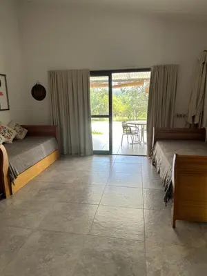 a bedroom with two beds and a view of a patio at Casita de los Reartes in Los Reartes