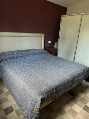 a bed with a blue comforter in a bedroom at Casita de los Reartes in Los Reartes