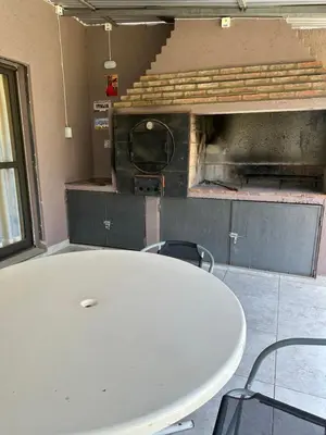 a white table and chairs in a kitchen with a oven at Casita de los Reartes in Los Reartes