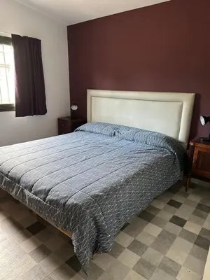 a bedroom with a bed with a blue comforter at Casita de los Reartes in Los Reartes