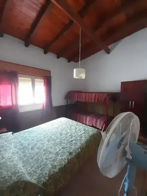 a bedroom with a bed with a fan and a window at Don Nene in Villa Cura Brochero