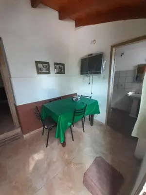 a dining room with a green table and chairs at Don Nene in Villa Cura Brochero