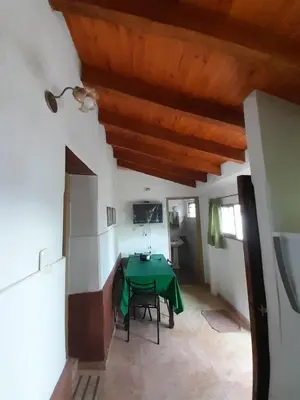 a dining room with a green table in a room at Don Nene in Villa Cura Brochero