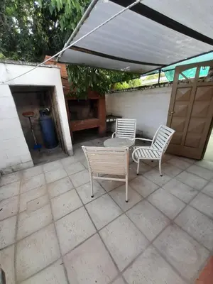 a patio with two chairs and a table and an umbrella at Don Nene in Villa Cura Brochero