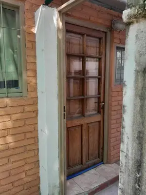 a wooden door on a brick building with a window at Don Nene in Villa Cura Brochero