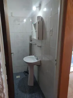 a white bathroom with a sink and a mirror at Tia Clau 1 in Villa Cura Brochero