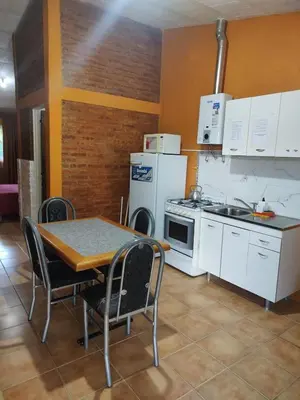 a kitchen with a table and a kitchen with white appliances at Tia Clau 1 in Villa Cura Brochero