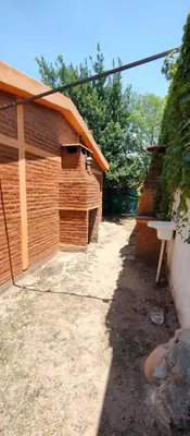a building with a fence next to a yard at Tia Clau 1 in Villa Cura Brochero