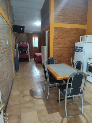 a dining room with a table and chairs and a kitchen at Tia Clau 1 in Villa Cura Brochero