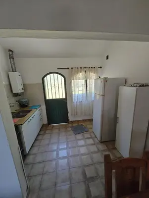 a kitchen with two refrigerators and a door to a room at Casa Villa Carlos Paz in Villa Carlos Paz