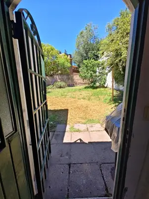 an open door to a yard with a gate at Casa Villa Carlos Paz in Villa Carlos Paz