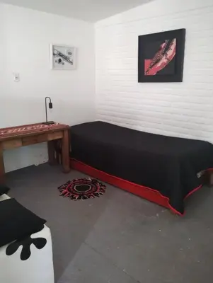 a bed in a room with a table and a bedspread at Kairós in Tanti