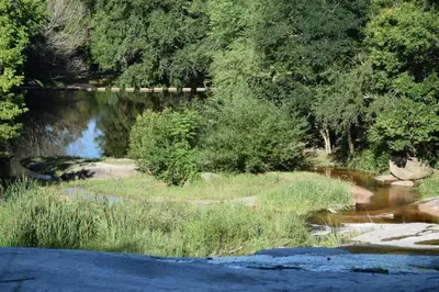 a body of water with trees and a bridge at Kairós in Tanti