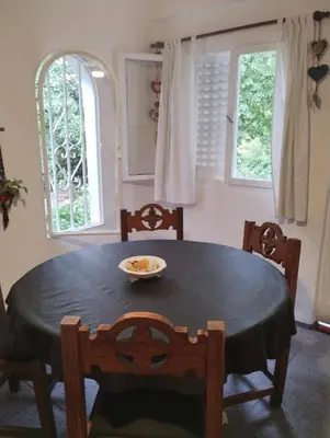 a dining room with a table and chairs and two windows at Kairós in Tanti