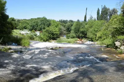 a river with snow on the rocks and trees at Kairós in Tanti