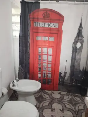 a red telephone booth in a bathroom with a toilet at Kairós in Tanti