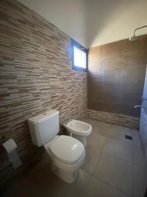 a bathroom with a white toilet and a sink at casa con pileta cerca de pekos y carlos paz in Villa Carlos Paz