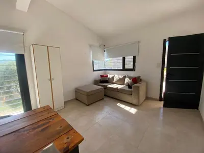 a living room with a couch and a window at casa con pileta cerca de pekos y carlos paz in Villa Carlos Paz