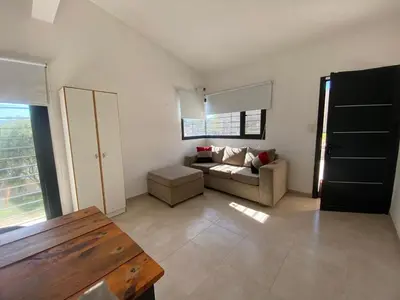 a living room with a couch and a window at casa con pileta cerca de pekos y carlos paz in Villa Carlos Paz