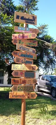 a street sign with many different signs on it at Hostel El Chinchero in Merlo