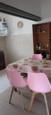 a table with two pink chairs in a kitchen at Hostel El Chinchero in Merlo