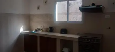a kitchen with a counter with a stove and a window at Hostel El Chinchero in Merlo
