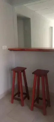 two wooden stools sitting in front of a counter at Hostel El Chinchero in Merlo