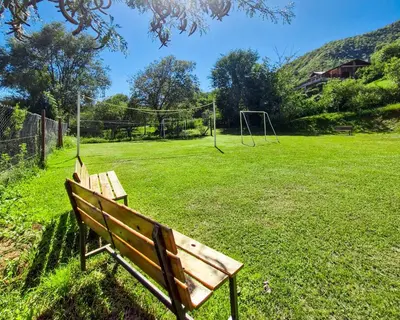 a park bench sitting in a field with a goal at Cabañas Balcon al Champaqui in Villa General Belgrano