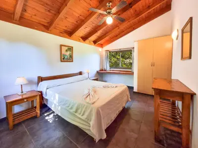 a bedroom with a bed and a wooden ceiling at Cabañas Balcon al Champaqui in Villa General Belgrano