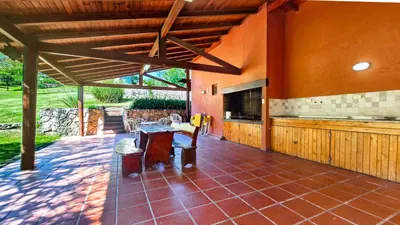 an outdoor patio with a fireplace in a house at Cabañas Balcon al Champaqui in Villa General Belgrano